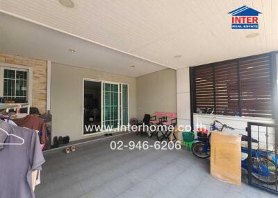 Covered patio with sliding doors leading to the interior, featuring various items