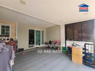 Covered patio with sliding doors leading to the interior, featuring various items