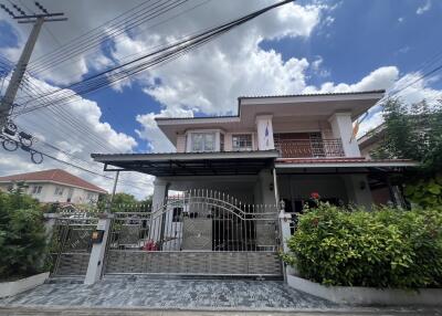 Exterior view of a residential house with a gated entrance and driveway