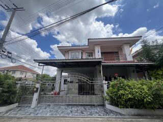 Exterior view of a residential house with a gated entrance and driveway