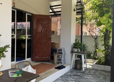 Covered outdoor patio with plants and furniture