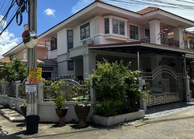 Two-story residential house with garden and driveway