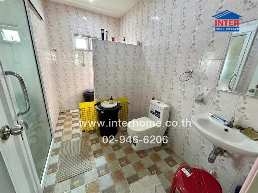 Bathroom with shower, toilet, sink, and tiled walls