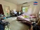 Bedroom with a double bed, window, and various personal items