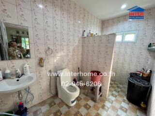 Bathroom with tiled walls and essential fixtures