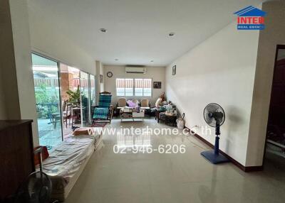 Spacious living room with large windows and sliding doors opening to a patio