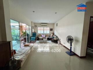 Spacious living room with large windows and sliding doors opening to a patio