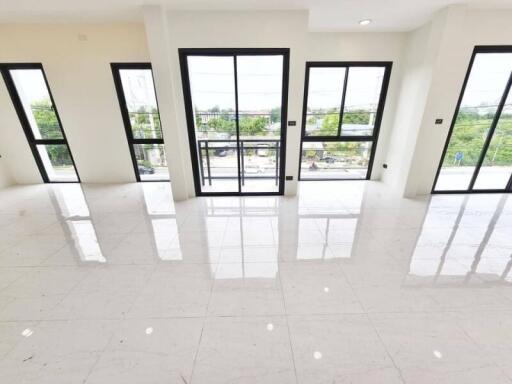 Bright and spacious living area with large windows and white tiled floor