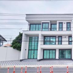 Modern three-story building with large windows and driveway