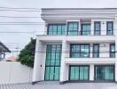 Modern three-story building with large windows and driveway