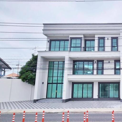 Modern three-story building with large windows and driveway