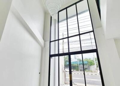 Tall room with large floor-to-ceiling windows and chandelier