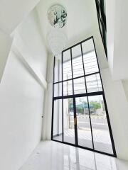 Tall room with large floor-to-ceiling windows and chandelier