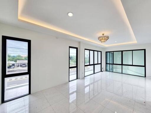 Spacious living room with large windows and modern chandelier