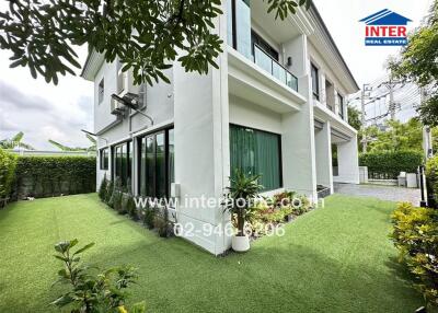 Modern two-story house with green lawn and large windows