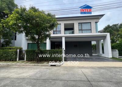 Modern two-story house with a garage and surrounding greenery