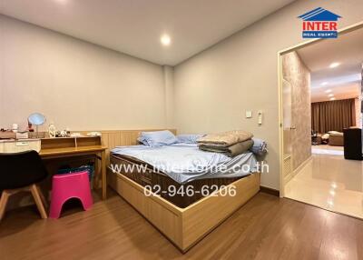 Spacious bedroom with wooden floor and modern furniture