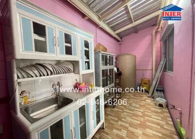 Kitchen with storage cabinets, dish rack, and sink