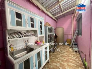 Kitchen with storage cabinets, dish rack, and sink