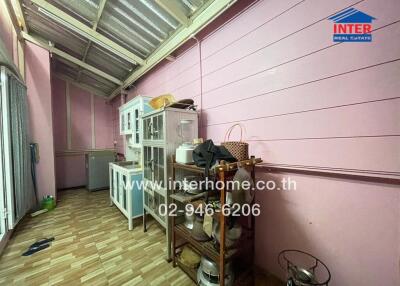 Indoor kitchen area with wooden and metal storage shelves, glass cabinet, and refrigerator.