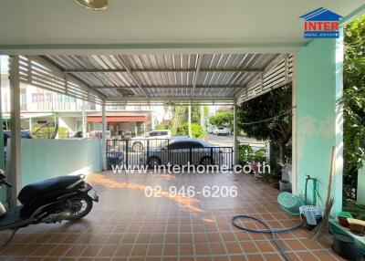 Covered outdoor area with tiled flooring and garden hose