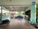 Covered outdoor area with tiled flooring and garden hose