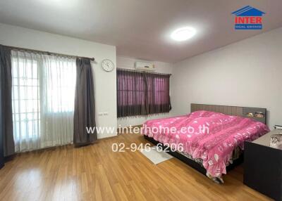 Bright bedroom with wooden flooring and large windows