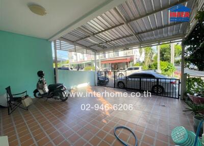 covered outdoor area with tiled floor, parked scooter and car