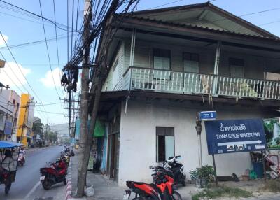 Exterior view of a two-story building along a street with parked motorbikes