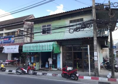 Street view of a building with commercial spaces and residential units above