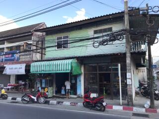 Street view of a building with commercial spaces and residential units above