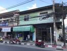 Street view of a building with commercial spaces and residential units above