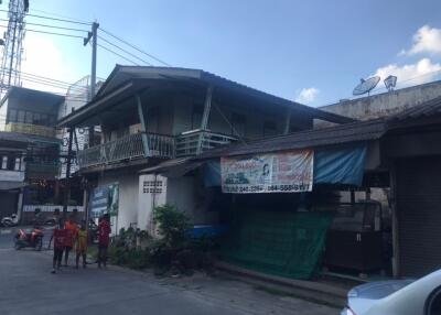 Front view of an older two-story building with overhang and balcony