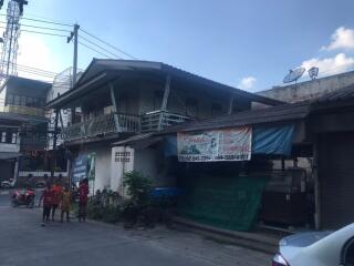 Front view of an older two-story building with overhang and balcony