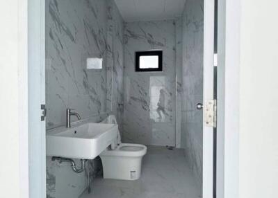 Modern white bathroom with wall-mounted sink and toilet