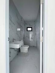 Modern white bathroom with wall-mounted sink and toilet