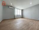 Spacious living room with wooden flooring and natural light