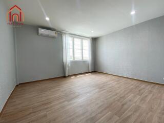 Spacious living room with large window and wooden flooring