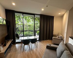 A cozy living area with large windows, showcasing a lush view of the garden.