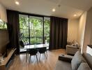 A cozy living area with large windows, showcasing a lush view of the garden.