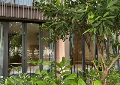 Exterior view of a home with large glass doors and lush greenery