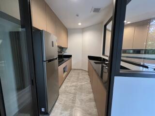 Modern kitchen with stainless steel appliances and reflective surfaces