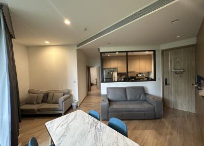 Modern open-plan living room and kitchen with grey furniture and a marble dining table