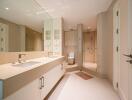 Modern bathroom with dual sinks, large mirror, and spacious shower area