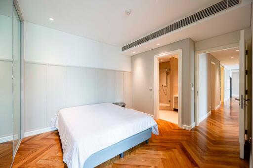 Modern bedroom with wooden floors and ensuite bathroom