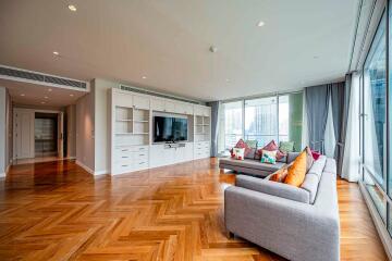 Spacious and modern living room with wooden flooring and large windows