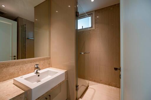 Modern bathroom with sink, mirror, and shower area.