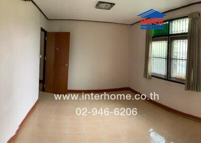 A bedroom with tiled floor, a window with curtains, and a door featuring a decorative painting.