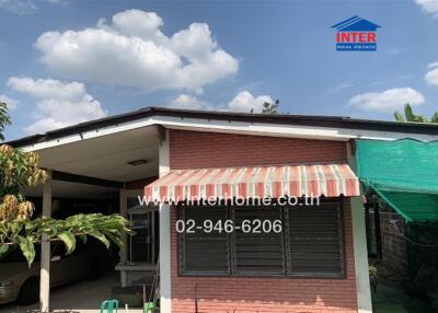 Exterior front view of the house with carport and awning