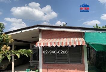 Exterior front view of the house with carport and awning